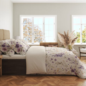 Side view of ivory bedding with scattered purple and lavender pansies, small yellow flowers and delicate gray-green leafy stems, showing the print across the draped cover.