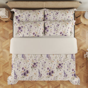 Overhead view of ivory bedding with scattered purple and lavender pansies, small yellow flowers and delicate gray-green leafy stems, with the design repeated on the pillows.