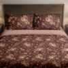 Front close view of burgundy bedding with densely scattered cream and dusty-pink roses, tiny blossoms and muted olive leaves on the cover and matching pillows.