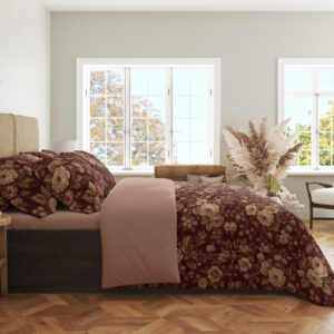 Side view of burgundy bedding with densely scattered cream and dusty-pink roses, tiny blossoms and muted olive leaves, showing the print across the draped cover.