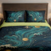 Front close view of deep-blue bedding with sweeping teal waves and clouds, cream foam, golden sun disks and delicate constellation-like lines on the cover and matching pillows.