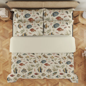 Overhead view of ivory bedding with small watercolor reef fish in blue, yellow, coral and gray swimming among delicate sea plants, with the design repeated on the pillows.
