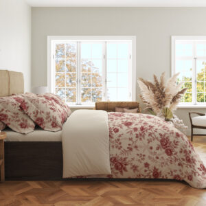 Side view of ivory bedding with a fine garnet-red repeat of roses, small blossoms and curling leafy sprigs, showing the print across the draped cover.