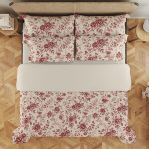 Overhead view of ivory bedding with a fine garnet-red repeat of roses, small blossoms and curling leafy sprigs, with the design repeated on the pillows.