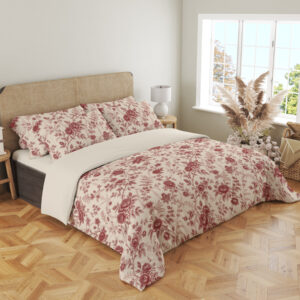 Angled full-bed view of ivory bedding with a fine garnet-red repeat of roses, small blossoms and curling leafy sprigs, showing the pattern across the cover and pillows.