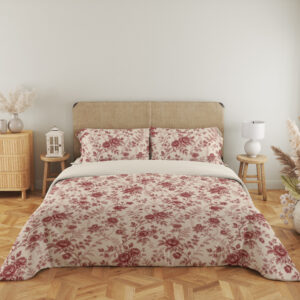 Full front view of ivory bedding with a fine garnet-red repeat of roses, small blossoms and curling leafy sprigs beneath a beige headboard.