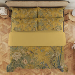Overhead view of ochre yellow bedding printed with small birds, slender flowering branches, ivory blooms and muted green foliage, with the design repeated on the pillows.