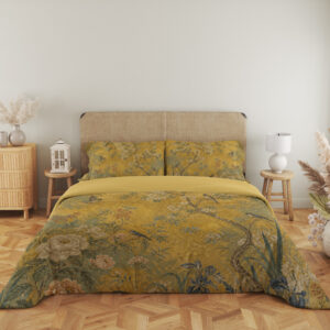 Full front view of ochre yellow bedding printed with small birds, slender flowering branches, ivory blooms and muted green foliage beneath a beige headboard.