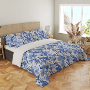 Angled full-bed view of ivory bedding with a dense indigo toile-style pattern of peacocks, flowering branches, leafy trees and garden foliage, showing the pattern across the cover and pillows.