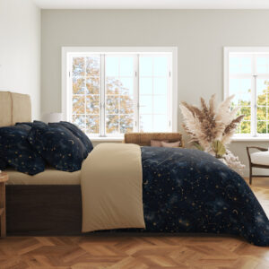 Side view of deep navy bedding with tiny pale stars, fine constellation lines, crescent moons and soft blue nebula-like patches, showing the print across the draped cover.