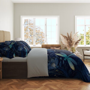 Side view of navy bedding printed with turquoise and pale green dragonflies among blue flowers and fine botanical sprigs, showing the print across the draped cover.