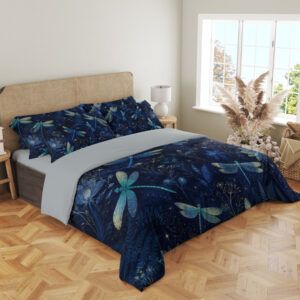 Angled full-bed view of navy bedding printed with turquoise and pale green dragonflies among blue flowers and fine botanical sprigs, showing the pattern across the cover and pillows.