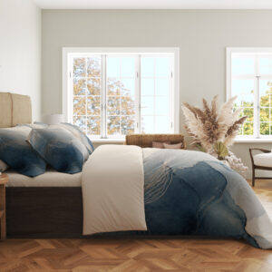 Side view of bedding printed with layered misty blue and gray watercolor contours, fine pale lines and an open ivory center, showing the print across the draped cover.