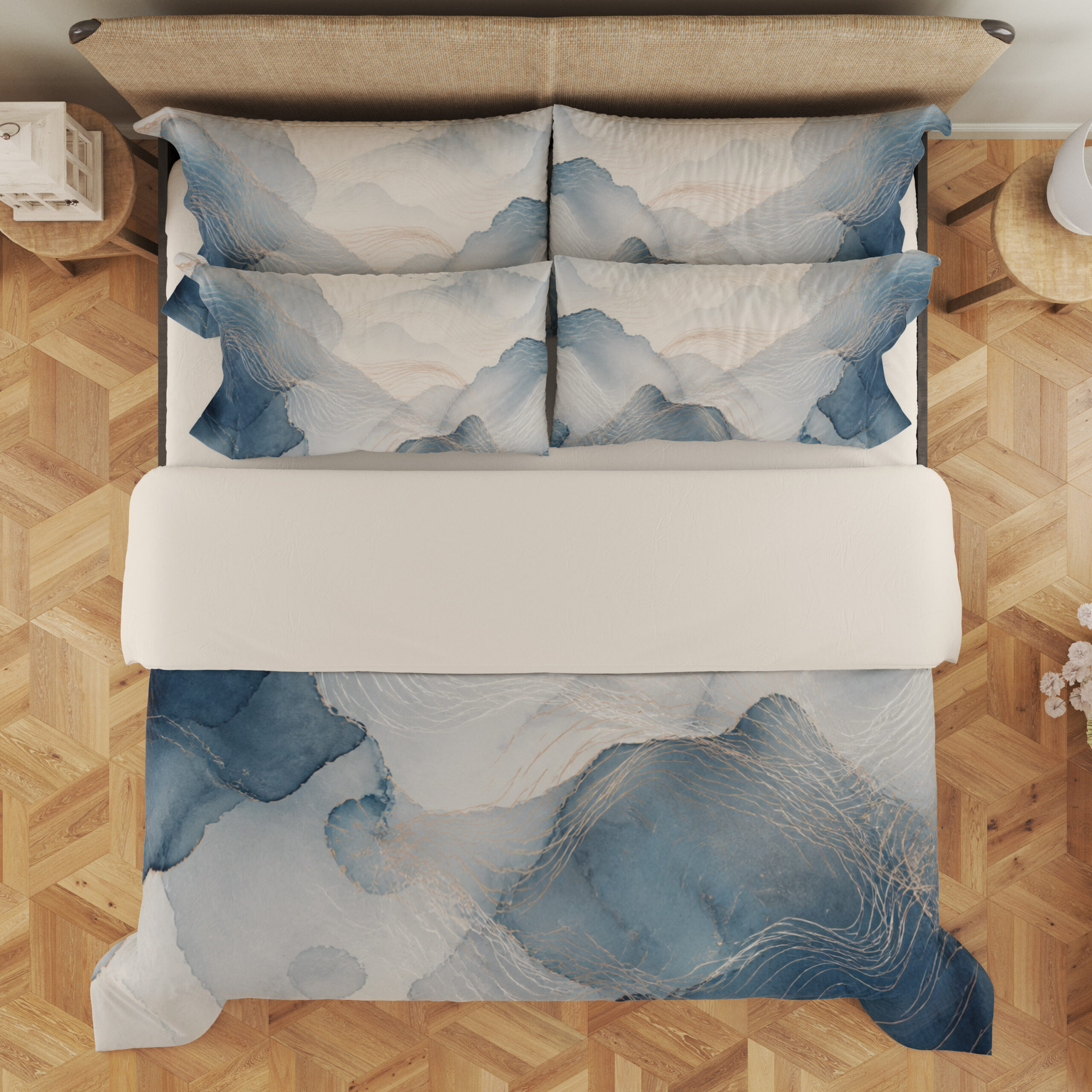 Overhead view of bedding printed with layered misty blue and gray watercolor contours, fine pale lines and an open ivory center, with the design repeated on the pillows.