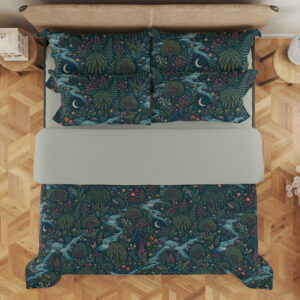 Overhead view of deep teal bedding printed with winding pale blue streams, dense green foliage, tiny red flowers and crescent moons, with the design repeated on the pillows.