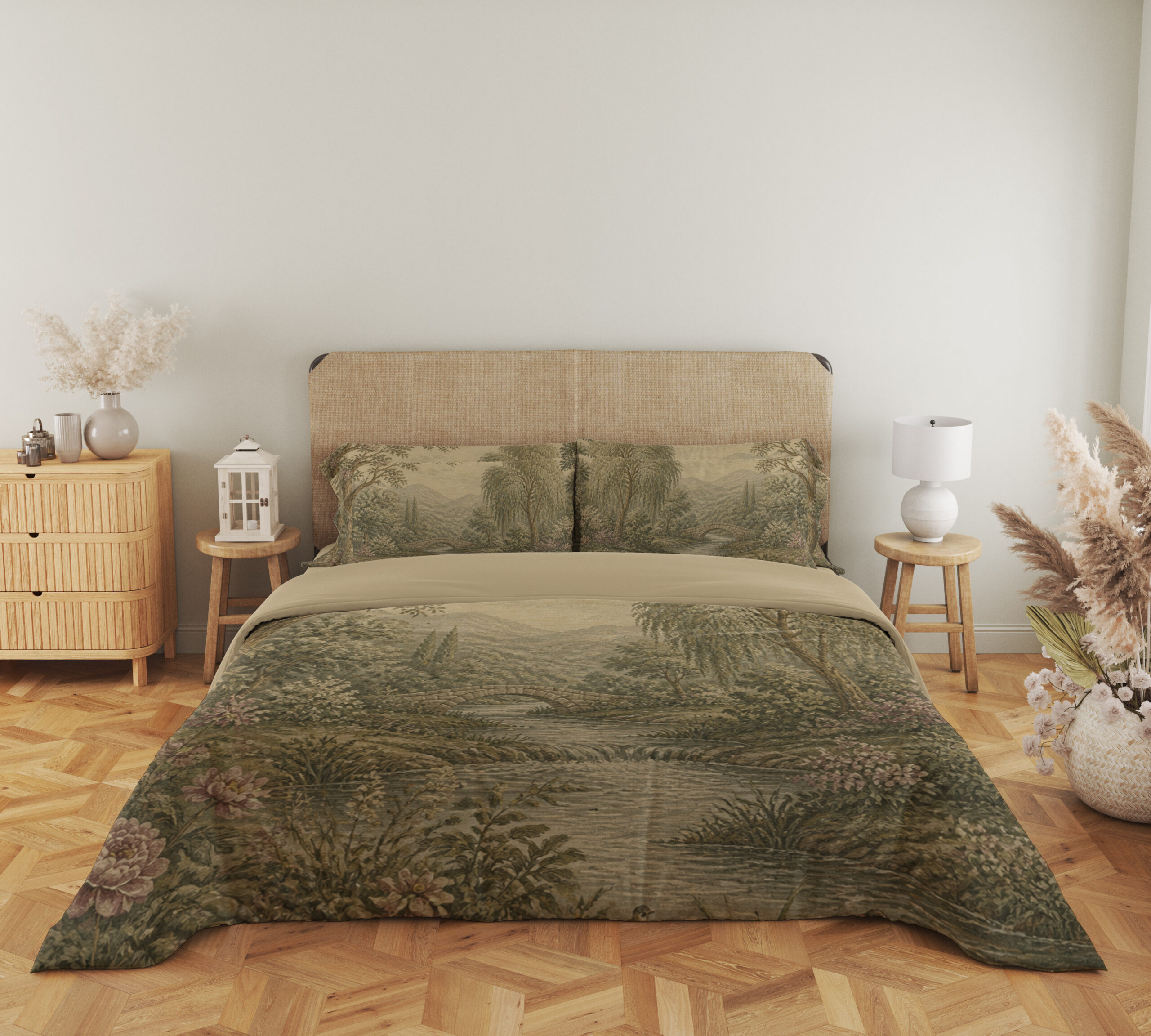 Full front view of muted sage-and-cream bedding with a wooded river landscape, layered trees, distant hills and small pink flowers along the banks beneath a beige headboard.