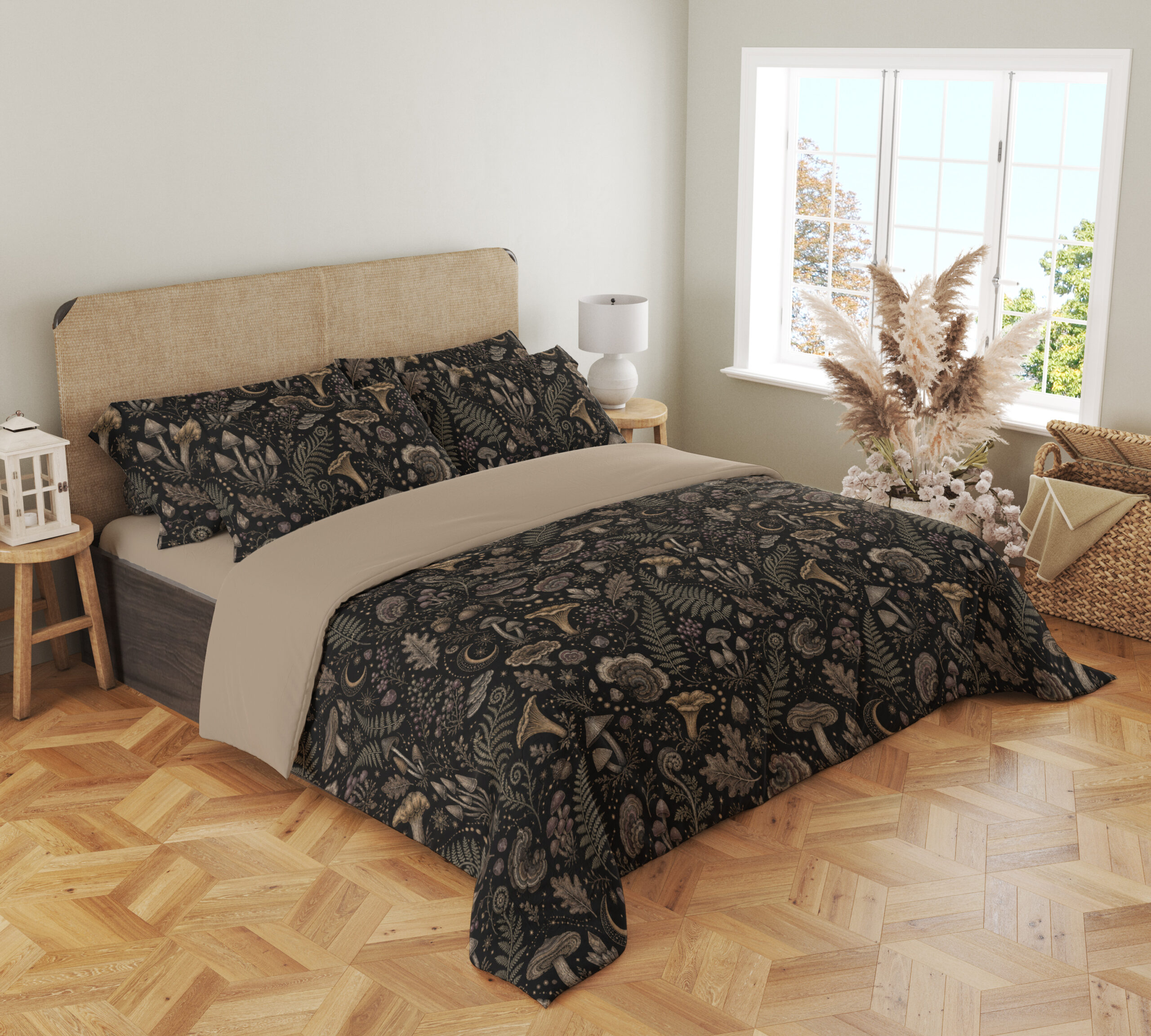 Angled full-bed view of charcoal bedding printed with a dense repeat of taupe mushrooms, fern fronds, leaves and small woodland flowers, showing the pattern across the cover and pillows.