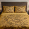 Front close view of ochre bedding with detailed sepia peonies, layered petals, rounded buds and slender leafy stems on the cover and matching pillows.