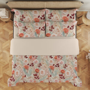 Overhead view of ivory bedding with a dense delicate repeat of coral-pink roses, burgundy leaves, pale teal foliage and tiny peach blossoms, with the design repeated on the pillows.