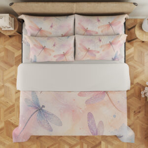 Overhead view of bedding printed with translucent pink, lavender and blue dragonflies over a soft peach, cream and pink watercolor ground, with the design repeated on the pillows.