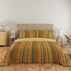 Full front view of bedding with narrow vertical saffron, cream, orange and olive stripes filled with tiny folk flowers, leaf stems and dotted borders beneath a beige headboard.