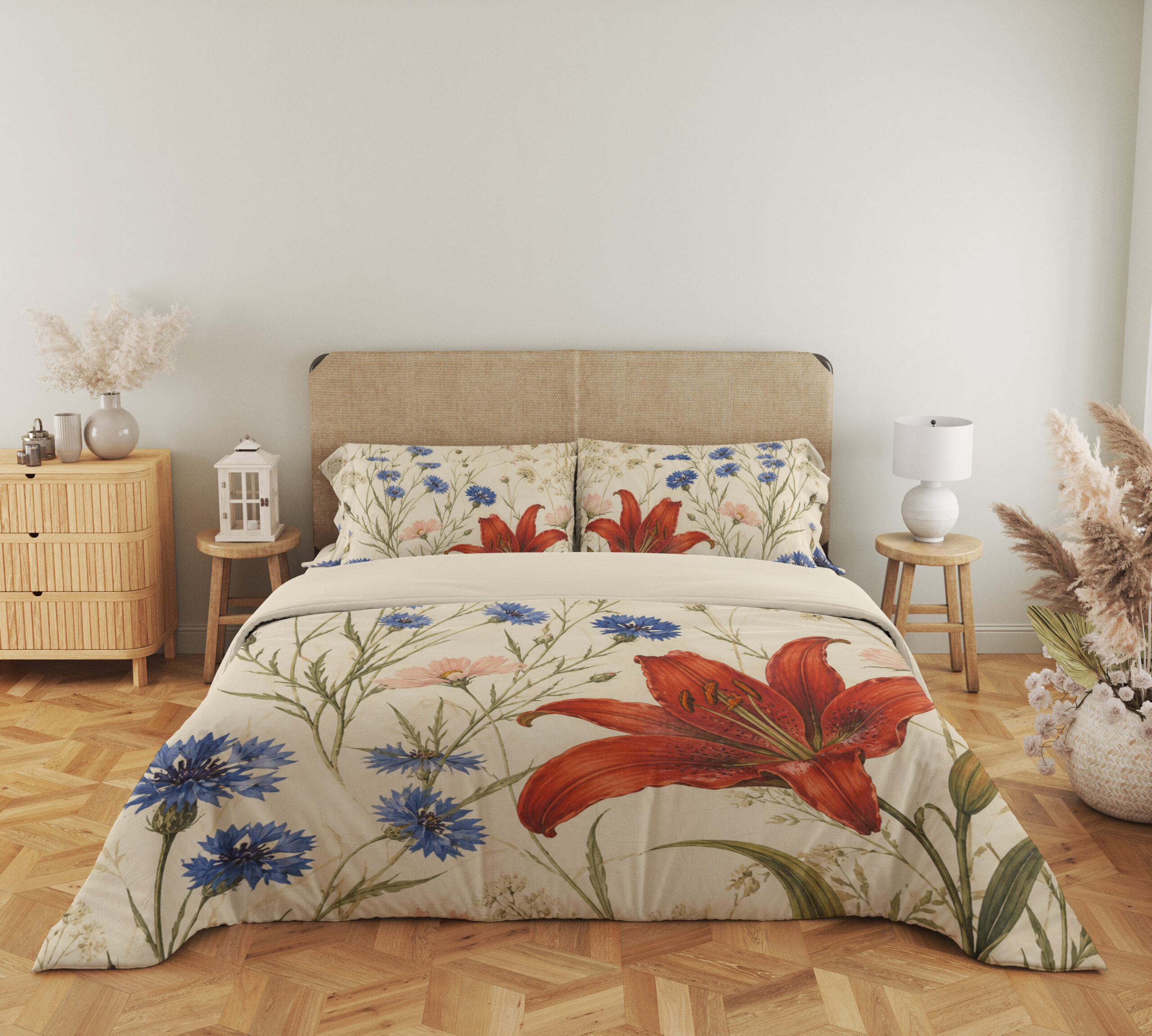 Full front view of cream bedding printed with large red lilies, blue cornflowers and fine green meadow stems beneath a beige headboard.
