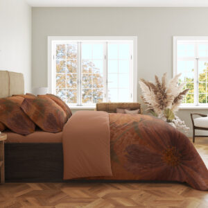 Side view of terracotta bedding with large softly painted orange dahlias, muted burgundy petals and shadowy olive leaves, showing the print across the draped cover.