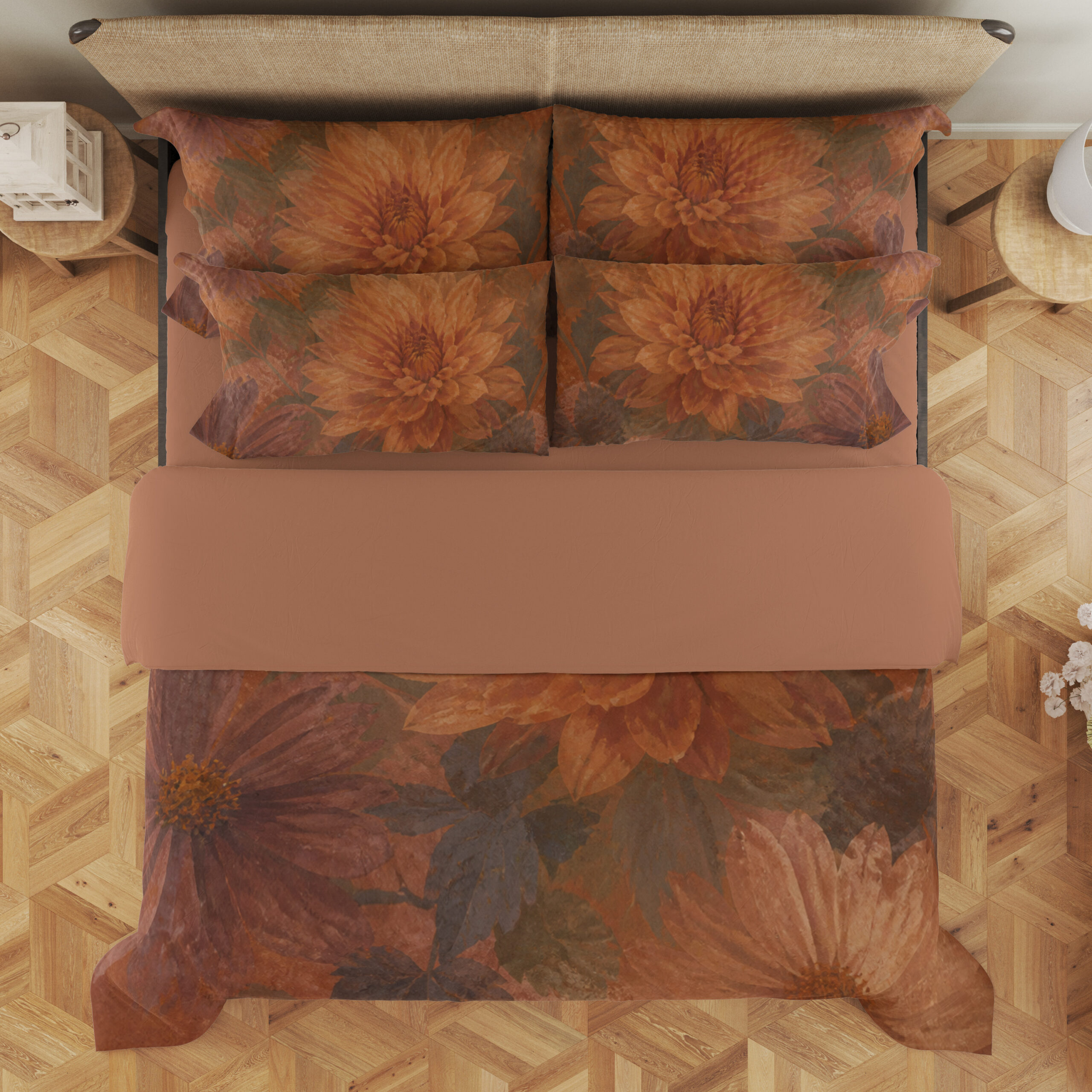 Overhead view of terracotta bedding with large softly painted orange dahlias, muted burgundy petals and shadowy olive leaves, with the design repeated on the pillows.