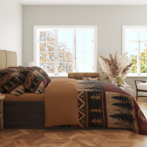 Side view of woodland patchwork bedding, showing black pine trees and ochre geometric bands on burgundy and tan panels.