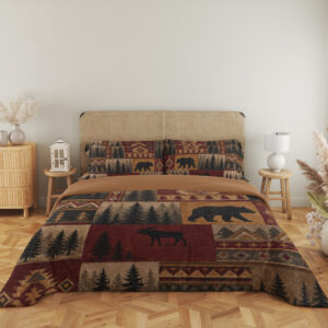 Full front view of bedding printed with burgundy, ochre and tan patchwork panels of black bears, moose, pine trees and geometric borders beneath a beige headboard.