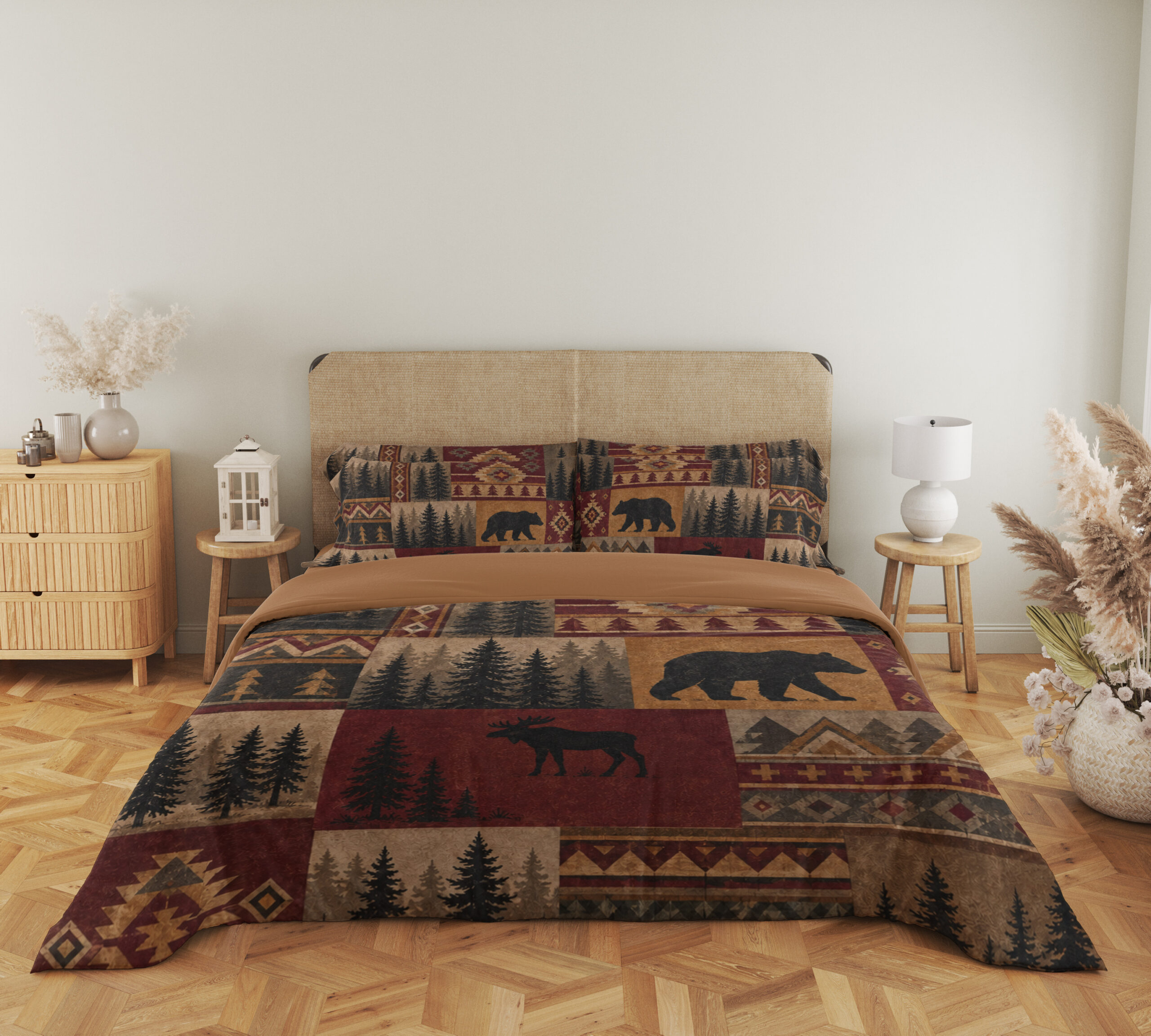 Full front view of bedding printed with burgundy, ochre and tan patchwork panels of black bears, moose, pine trees and geometric borders beneath a beige headboard.