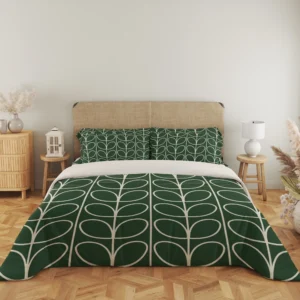 Full front view of green bedding with tall ivory leaf stems, matching patterned pillows and a pale fold across the head of the duvet.