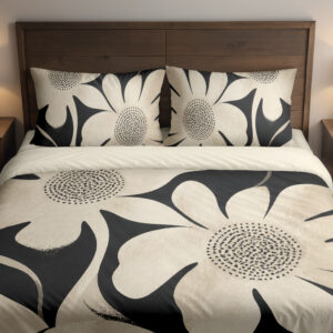 Front close view of charcoal bedding printed with oversized ivory flowers, curved petals and finely dotted centers on the cover and matching pillows.