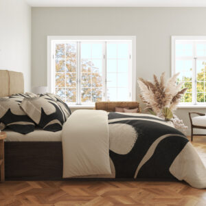 Side view of charcoal floral bedding, showing oversized ivory petal shapes across the draped cover.