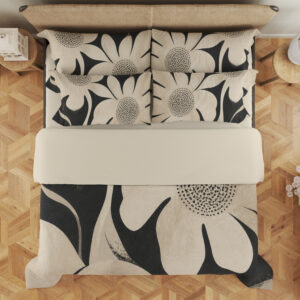 Overhead view of charcoal bedding printed with oversized ivory flowers, curved petals and finely dotted centers, with the design repeated on the pillows.