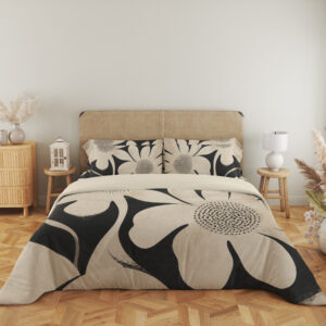 Full front view of charcoal bedding printed with oversized ivory flowers, curved petals and finely dotted centers beneath a beige headboard.