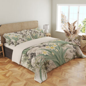 Angled full-bed view of ivory bedding printed with white and yellow narcissus flowers, long sage leaves and dark mossy rock formations, showing the pattern across the cover and pillows.
