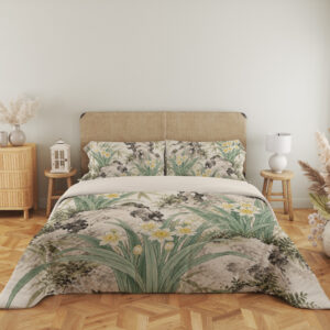 Full front view of ivory bedding printed with white and yellow narcissus flowers, long sage leaves and dark mossy rock formations beneath a beige headboard.