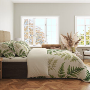 Side view of ivory bedding printed with scattered forest-green and olive fern fronds of different sizes, showing the print across the draped cover.