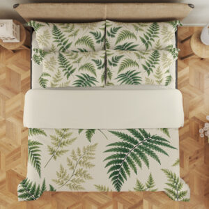 Overhead view of ivory bedding printed with scattered forest-green and olive fern fronds of different sizes, with the design repeated on the pillows.