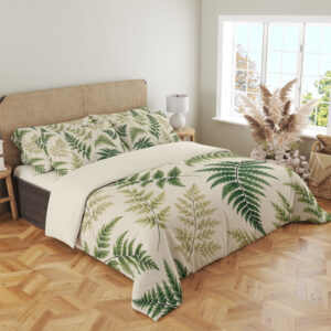 Angled full-bed view of ivory bedding printed with scattered forest-green and olive fern fronds of different sizes, showing the pattern across the cover and pillows.