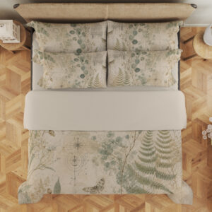 Overhead view of parchment bedding printed with sage fern fronds, round eucalyptus-like leaves, delicate grasses and small moth motifs, with the design repeated on the pillows.