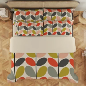 Overhead view of cream bedding with colorful tilted leaves in vertical columns, continuing across layered pillows above a broad pale fold.