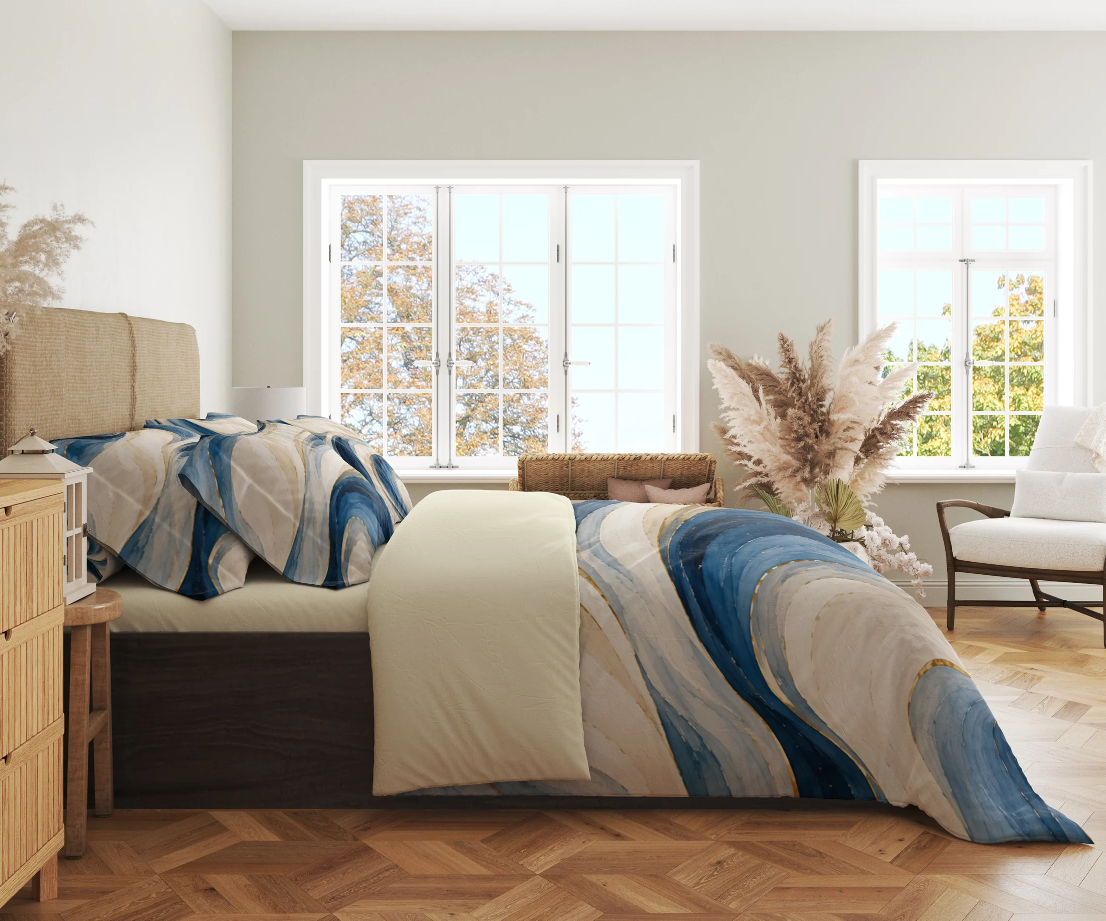 Side view of the ivory and blue ribbon duvet cover with gold-colored accents and matching pillowcases in a bright room with large windows.