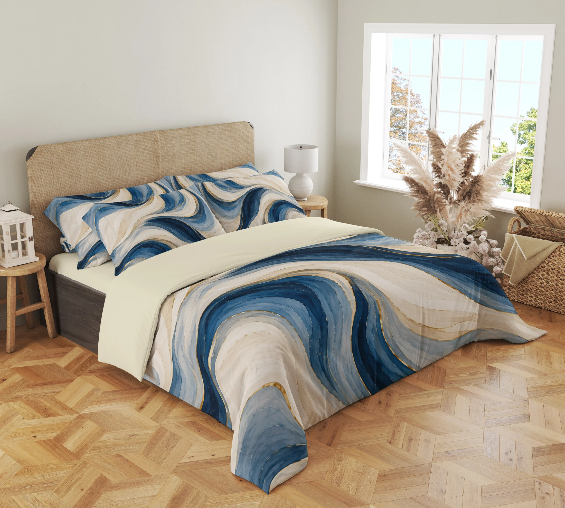 Three-quarter view of the ivory and blue painted ribbon duvet cover with gold-colored accents and matching pillows beside a window and dried grasses.