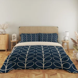 Straight-on view of the complete navy duvet with cream outlined leaf columns and matching pillows above a narrow cream fold.