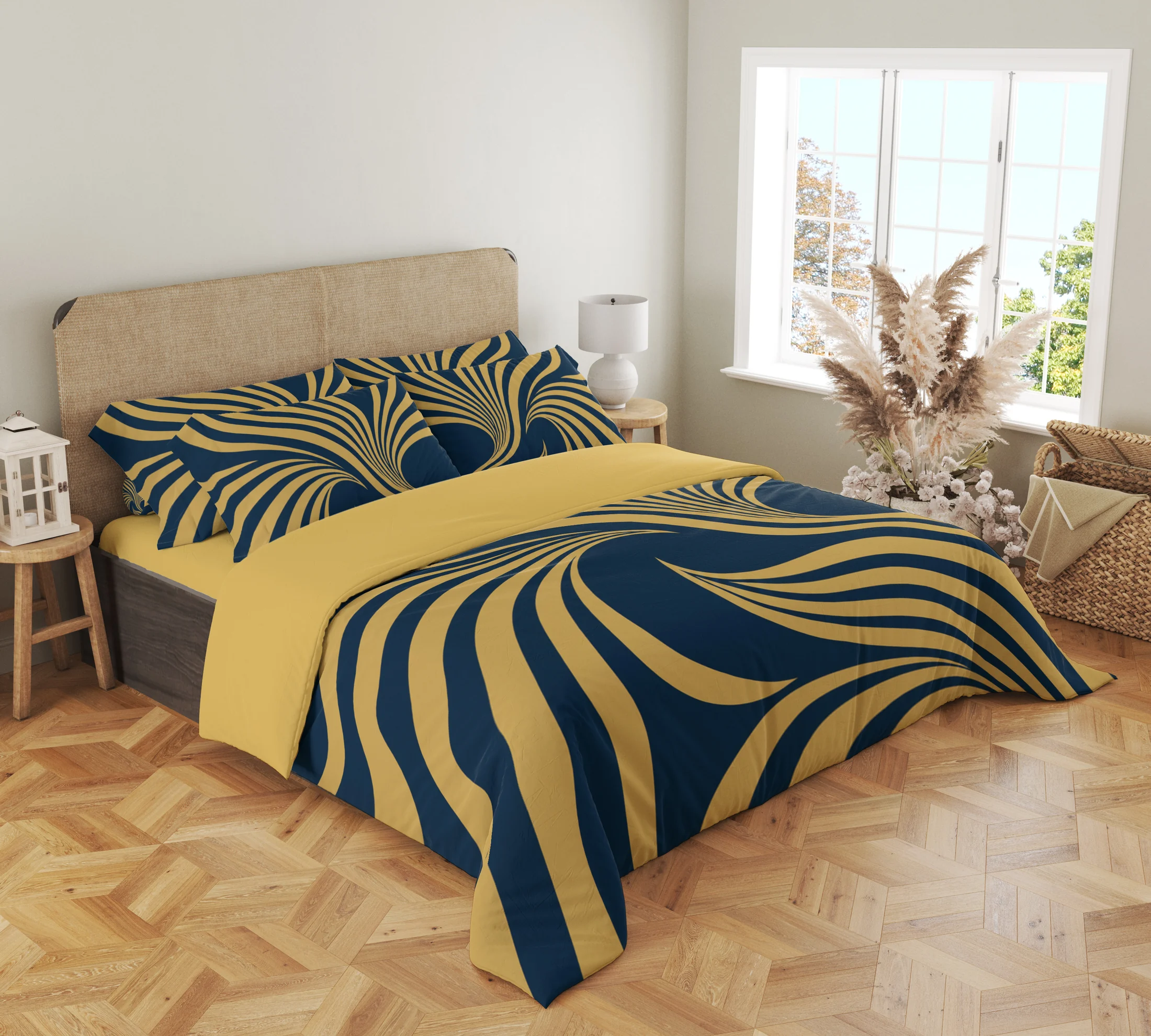 Three-quarter view of navy and gold-colored ribbon bedding, showing printed fan-pattern pillows and broad ribbons draping over the front corner.