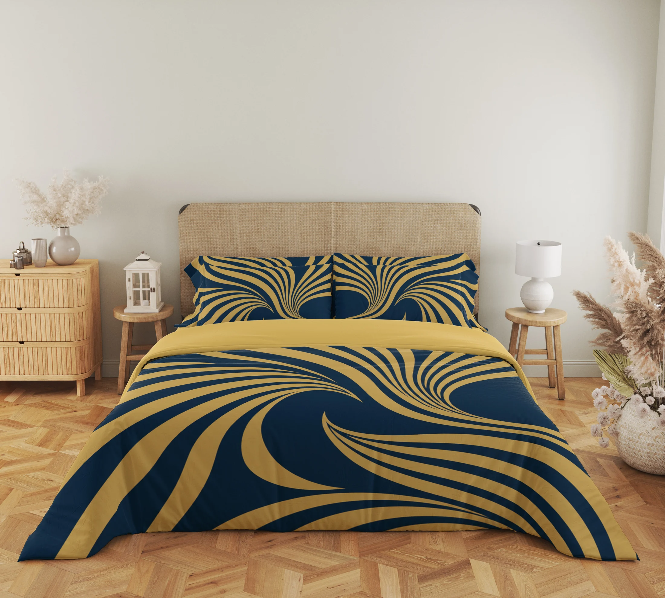 Close frontal view of navy and gold-colored fan-ribbon bedding with two printed pillows and a plain gold-colored fold above the duvet.
