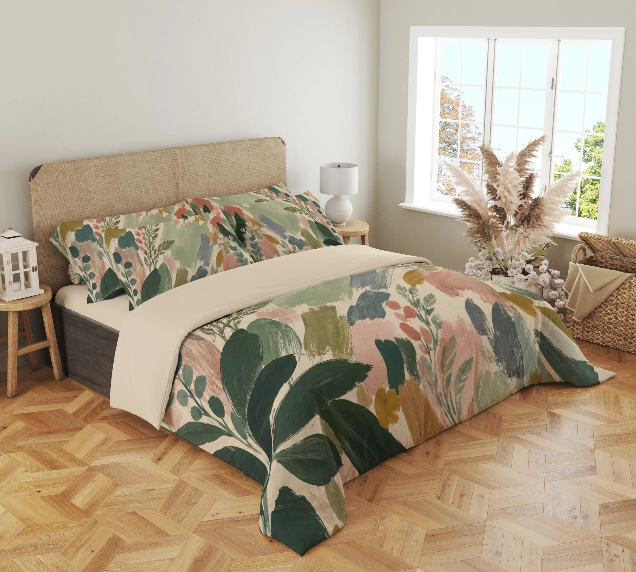 Three-quarter bedroom view of sage and blush brushstroke bedding, with dark green leaves draping over the front corner beside a woven headboard.