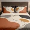 Front view of cream, terracotta and gray organic-shape bedding with an ochre accent and a wandering charcoal line, styled against a dark wood headboard.